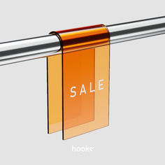 an orange sale sign hanging from a metal bar with the word sale printed on it