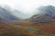 a river running through a valley surrounded by mountains