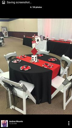 the table is set up with black and red cloths, white chairs, and mickey mouse centerpieces