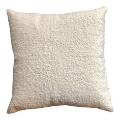 a white pillow that is made out of sheepskin and has a square shape on the front