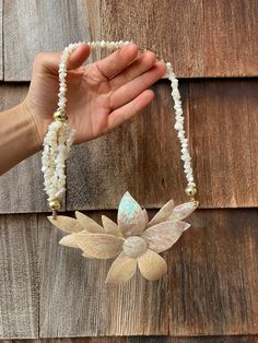 This necklace has an extra large flower pendant centerpiece with curved petals and a layered design. The Mother of Pearl covered petals have a crazed texture that look like a shell mosaic with iridescent hues. The back of the flower looks like it was covered in a hard molded clay-like material. The strands are lined with jagged Mother of Pearl shell beads and one section has multiple little strands to add asymmetry to the design. There is a large barrel style clasp at the top and the necklace measures about 10 inches in drop length, including the pendant. Handmade Mother Of Pearl Flower Necklace, Handmade Flower Shaped Necklaces, Shell Mosaic, Costume Jewelry Necklaces, Layered Design, Pearl Shell, Bracelet Crafts, Shell Beads, Vintage Costume Jewelry