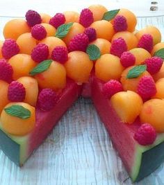 there is a cake made out of fruit on top of a wooden table with one slice missing from it