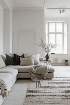 a living room filled with furniture and a large rug on top of a white floor