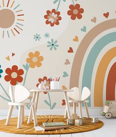 two children's chairs and table in front of a wall with flowers on it