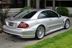 a silver sports car parked in front of a building