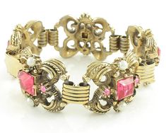 "Vintage Victorian Revival Pink Rhinestone Imitation Pearl Bracelet and Clip On Earring Set. The chunky gold tone bracelet and earrings are set with square and round pink rhinestones and simulated glass pearls. The bracelet links are connected by book link style links. The bracelet is 7 inches long and 15/16 inch wide and the earrings measure approximately 7/8 inch X 1 inch. Finished with a fold over clasp. In Excellent Vintage Condition with no damage noted. ERA: Retro, 1950s METAL/MATERIALS: G Vintage Jeweled Jewelry For Evening, Retro Jeweled Wedding Jewelry, Vintage Rhinestone Jewelry For Vintage Events, Retro Metal Jewelry, Vintage Adjustable Jewelry With Rhinestones, Vintage Jeweled Jewelry For Parties, Antique Jeweled Jewelry For Vintage Events, Vintage Collectible Jewelry With Stone Setting, Collectible Vintage Jeweled Jewelry