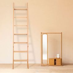 a ladder leaning against a wall next to a wooden cabinet with a mirror on it