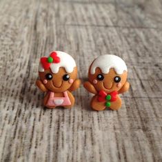 two little gingerbread man and woman figurines sitting on a table next to each other