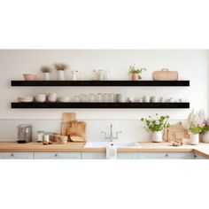 two black shelves above a kitchen sink filled with dishes