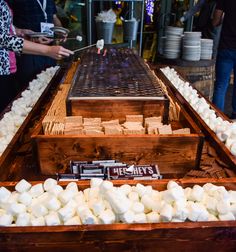 marshmallows are being cooked on an outdoor grill in the middle of a market