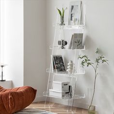 a living room with a chair, bookshelf and vases on the floor