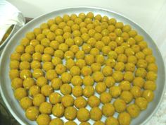 there is a large plate full of yellow balls on the stove top, ready to be cooked