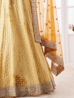 Precise beauty can come out from your dressing trend with this charming yellow lehenga choli in georgette material embellished with sequin, dori, stonework, and zarkan work. This beautiful yellow sequin lehenga comes with similar color blouse material adorned with the same design as the lehenga and comes with a similar color dupatta with dori, sequin, and stonework with zarkan. This yellow engagement wear lehenga is semi-stitched up to 42 inches and comes with fully unstitched blouse material. N Semi-stitched Anarkali Set With Gota Work For Wedding, Floor-length Gota Work Gown For Reception, Reception Gown With Gota Work, Floor-length, Floor-length Gown With Gota Work For Reception, Semi-stitched Long Choli With Zari Work, Organza Lehenga With Cutdana, Floor-length, Long Semi-stitched Choli With Zari Work, Floor-length Sharara With Gota Work For Reception, Festive Long Georgette Choli