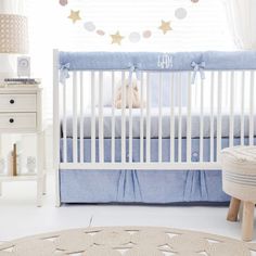 a baby's room with a crib, dresser and lamp