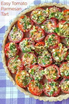 an easy tomato tart in a pie pan on a blue and white checkered table cloth