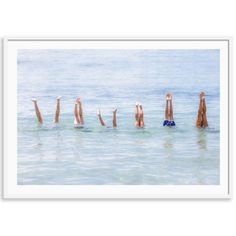 a group of people floating in the ocean with their hands up and feet out to sea