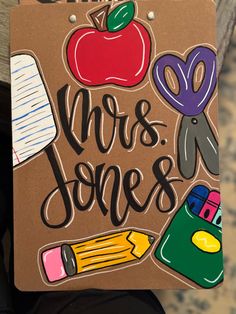 a sign that says mrs jones with school supplies on it and the words mrs jones written in black ink