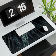 a computer desk with a keyboard and mouse on it next to a potted plant