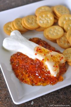 crackers, cheese and sauce on a white plate