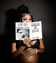 a pregnant woman holding up signs with the words coming soon