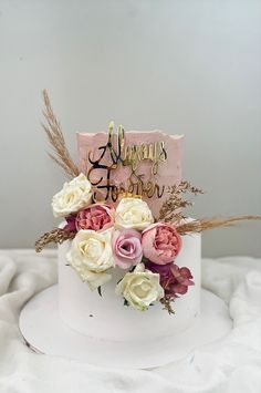 a pink and white cake with flowers on top