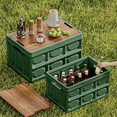 an outdoor picnic table made out of two large green containers with compartments for drinks and condiments