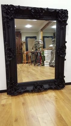 a large mirror sitting on top of a wooden floor