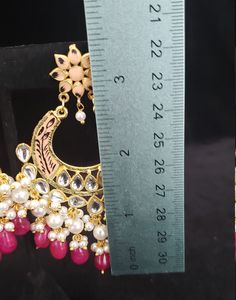 "This beautiful Kundan earrings set has an excellent finish and gives out an exquisite sense of style. If you are looking for an amazing Fashion Jewelry set for special occasions such as Anniversary, Engagement, Party, Wedding, gifting, then your search ends here. This handmade Indian Jewelry is best to wear for traditional ceremonies or Indian weddings. This bridal jewelry has an ethnic finish. It has Cubic Zircon stones with semi-precious ruby and emeralds. It is a Bollywood style one-gram jew Traditional Chandbali Earrings With Dangling Beads, Traditional Chandbali Jewelry With Dangling Beads, Elegant Kundan Danglers With Dangling Beads, Elegant Kundan Danglers With Beads, Traditional Dangling Beads Earrings For Celebration, Traditional Earrings With Dangling Beads For Celebration, Temple Jewelry Earrings With Dangling Beads For Gift, Elegant Kundan Chandbali Necklace With Dangling Beads, Traditional Kundan Earrings With Dangling Beads