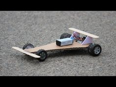 a toy car made out of wood with wheels and an electronic device attached to it