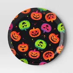 a black plate with halloween pumpkins and skulls on it's sides, all painted in bright colors