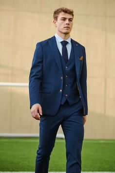 Official Leicester City F.C. Club Suit! From the daily grind to the office boardroom, make a sartorial statement with this Max three-piece suit, the official club suit of Leicester City first team. The sleek silhouette exudes confidence and is complemented by the subtle tan hue, allowing it to stand out in the ocean of mundane office attire. To add an extra touch of sophistication, an alluring circle print pocket square adds a modern finishing touch that turn heads. This suit is the perfect piec Navy Suits For Office Wear With Collar, Single-breasted Three-piece Suit With Suit Collar For Office, Professional Three-piece Suit With Notch Lapel For Office, Navy Fitted Suit For Office Wear, Navy Three-piece Suit For Business Casual, Workwear Suits With Suit Collar, Navy Tailored Suits For Office, Tailored Navy Suits For Office, Tailored Suit With Suit Collar For Office