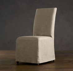 an upholstered chair on a wooden floor in front of a gray wall and wood floors