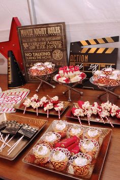 desserts are displayed on trays at a movie themed party