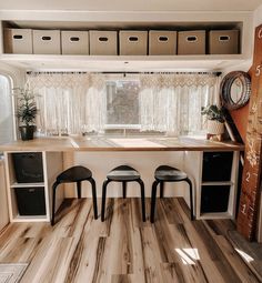 the inside of a camper with two stools and a kitchen table in it