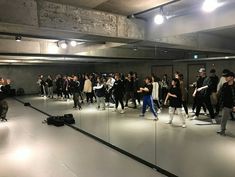 a group of people standing in a room with mirrors