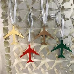 three wooden airplanes are hanging from strings on a wall ornament in the shape of an airplane