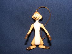 a yellow and white cartoon figure is on a blue surface with a cord in the shape of a mouse