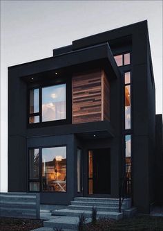 a modern house with large windows and steps leading up to it