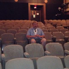 a man sitting in the middle of an empty auditorium