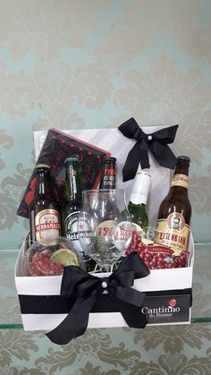 a wine gift box filled with alcohol and liquor bottles on a glass table next to a wall