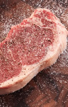 a piece of raw meat sitting on top of a cutting board covered in powdered sugar