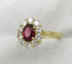 Sale.  Originally $2,975.00 A very pretty oval mixed cut Red Spinel surrounded by diamonds.  This spinel has a gorgeous red color and the diamonds surrounding the ring add a lovely sparkle and contrast.  A perfect non-traditional engagement ring. Overview: The ring is prong set with a oval mixed cut Red Spinel.  Prong set around the center stone are ten (10) round brilliant cut diamonds.  The top of the ring measures 12.0mm x 10.7mm x 6.1mm. The shank measures 1.40mm wide and 1.1mm thick. Size 6 Dazzling Oval Ruby Ring With Diamonds, Dazzling Oval Ruby Ring, Oval Ruby Cluster Ring With Rose Cut Diamonds, Oval Ruby Halo Ring With Brilliant Cut, Red Oval Cluster Ring With Rose Cut Diamonds, Red Diamond Cluster Ring With Halo Setting, Oval Ruby Ring With Diamond Halo, Dazzling Oval Ruby Ring With Halo Setting, Classic Red Oval Cluster Ring