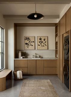 a modern kitchen with wood cabinets and an area rug in front of the countertop