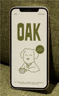 a sign that says oak with a dog holding a bowl in its mouth and sitting on a couch