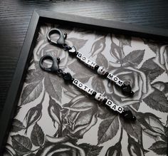 two pairs of scissors sitting on top of a table next to a flowered wallpaper