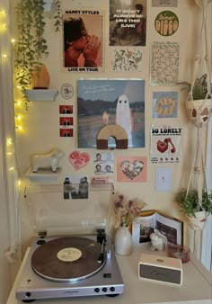 a record player sitting on top of a table next to a wall covered in pictures