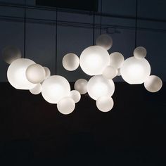 a group of lights hanging from the ceiling in a dark room with no one around them