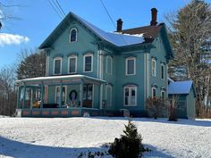 a large blue house with snow on the ground