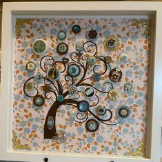 a tree made out of buttons in a frame