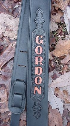 a guitar case sitting on the ground with leaves around it and an inscription that reads, gorgon